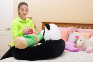 girl with stuffed panda sleeping bag and bamboo pillow