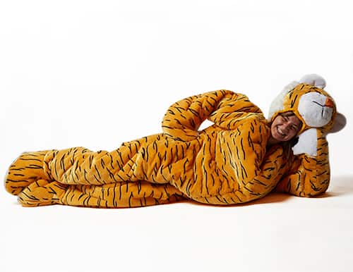 woman lounging in snoozoo plush tiger sleeping bag