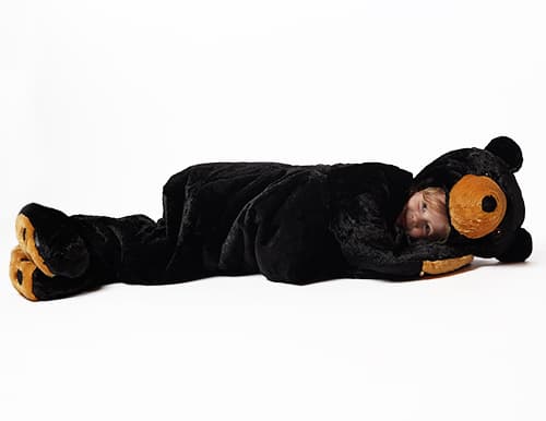 child laying down wearing stuffed black bear sleeping bag