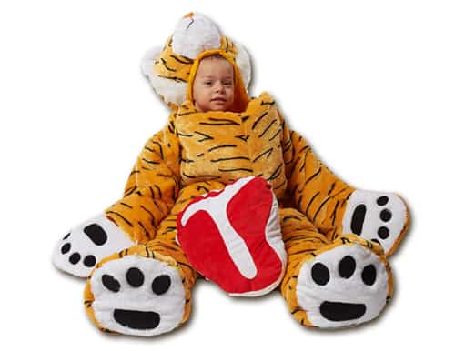 child sitting wearing tiger sleep sack with steak pillow